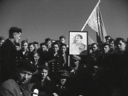 Ryska krigsfångar från Norge samlade utomhus i Sundsvall kring ett porträtt på Josef Stalin, rysk fana i bakgrunden.