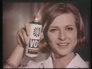 Närbild av en kvinna som håller upp en burk med hårspray av märket Vo5.