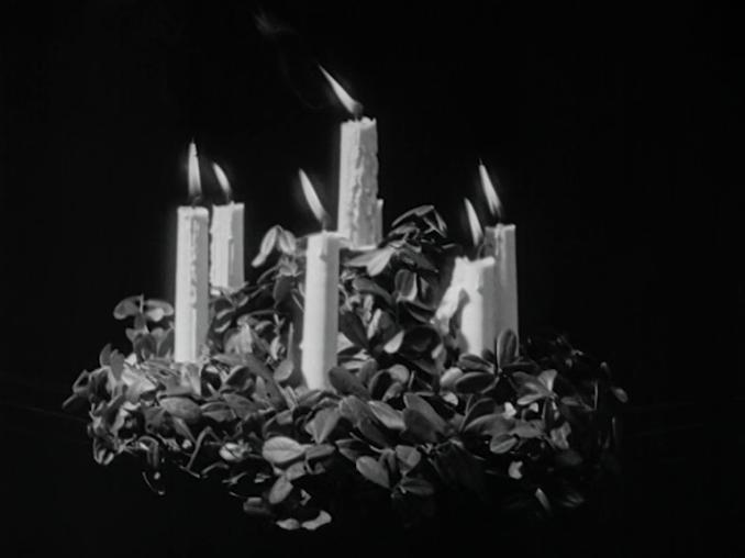 Luciakrona med sju brinnande stearinljus.